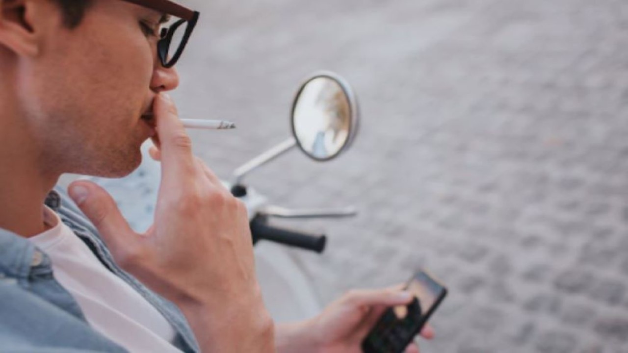 Ilustrasi pengendara motor sedang merokok. (Freepik)