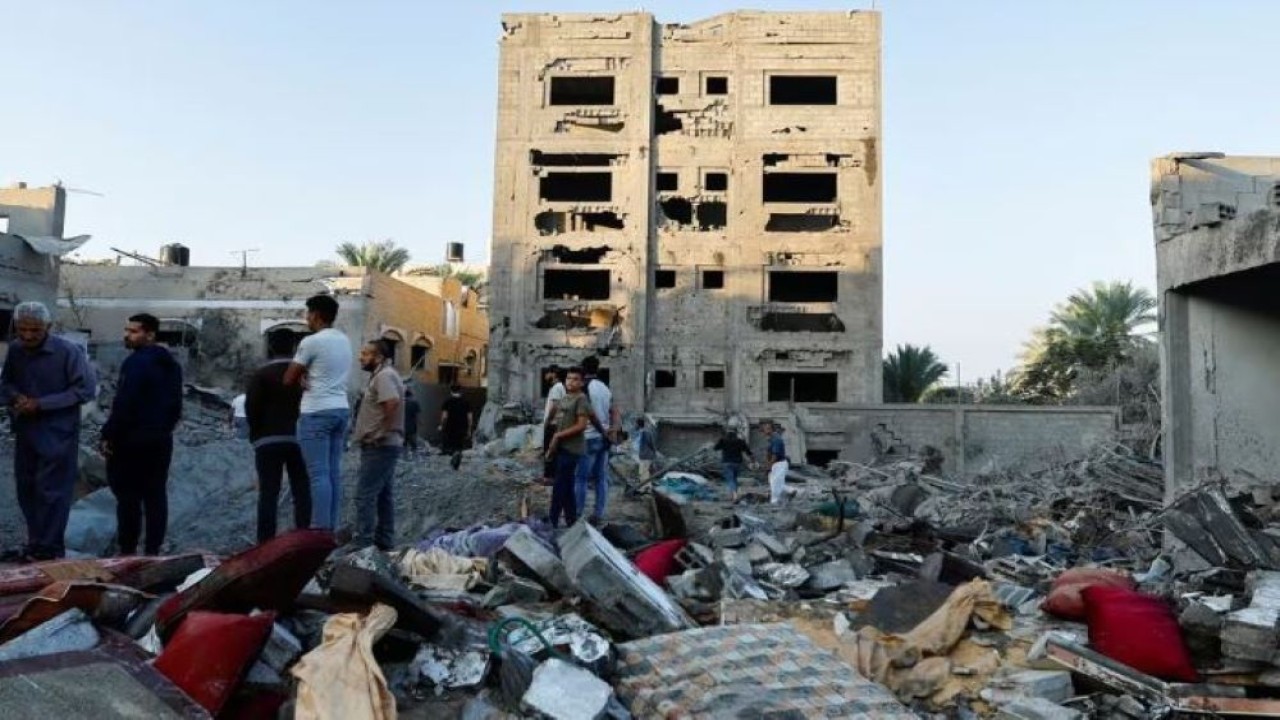 Warga Palestina melihat hancurnya sebuah rumah pasca serangan di tengah konflik dengan Israel di Khan Younis, di Jalur Gaza selatan, 12 Oktober 2023. (Foto: Dok/Ibraheem Abu Mustafa/Reuters)