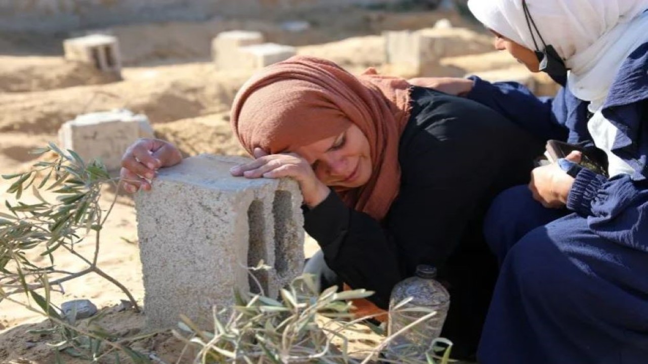 Seorang perempuan Palestina menangis di makam putranya yang tewas dalam serangan Israel, di Khan Younis, Gaza. (Foto: Arafat Barbakh/Reuters)
