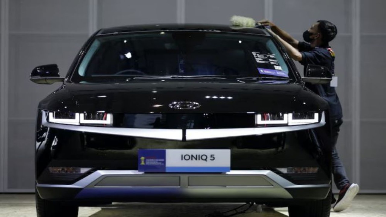 Seorang pekerja membersihkan mobil listrik Hyundai Ioniq 5 saat pameran otomotif Indonesia International Motor Show (IIMS) di Jakarta, Indonesia, 16 Februari 2023. (Foto: Willy Kurniawan/Reuters)