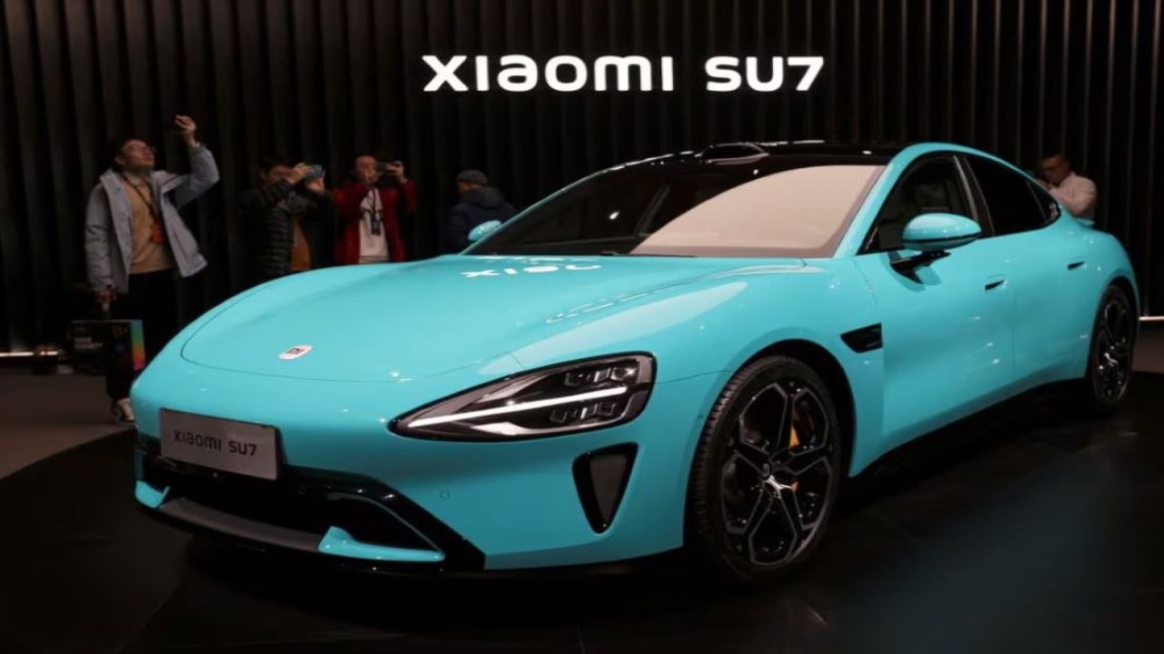 Pengunjung merekam kendaraan listrik pertama Xiaomi, SU7, yang ditampilkan di sebuah acara di Beijing, China, pada 28 Desember 2023. (Foto: Dok/Florence Lo/Reuters)