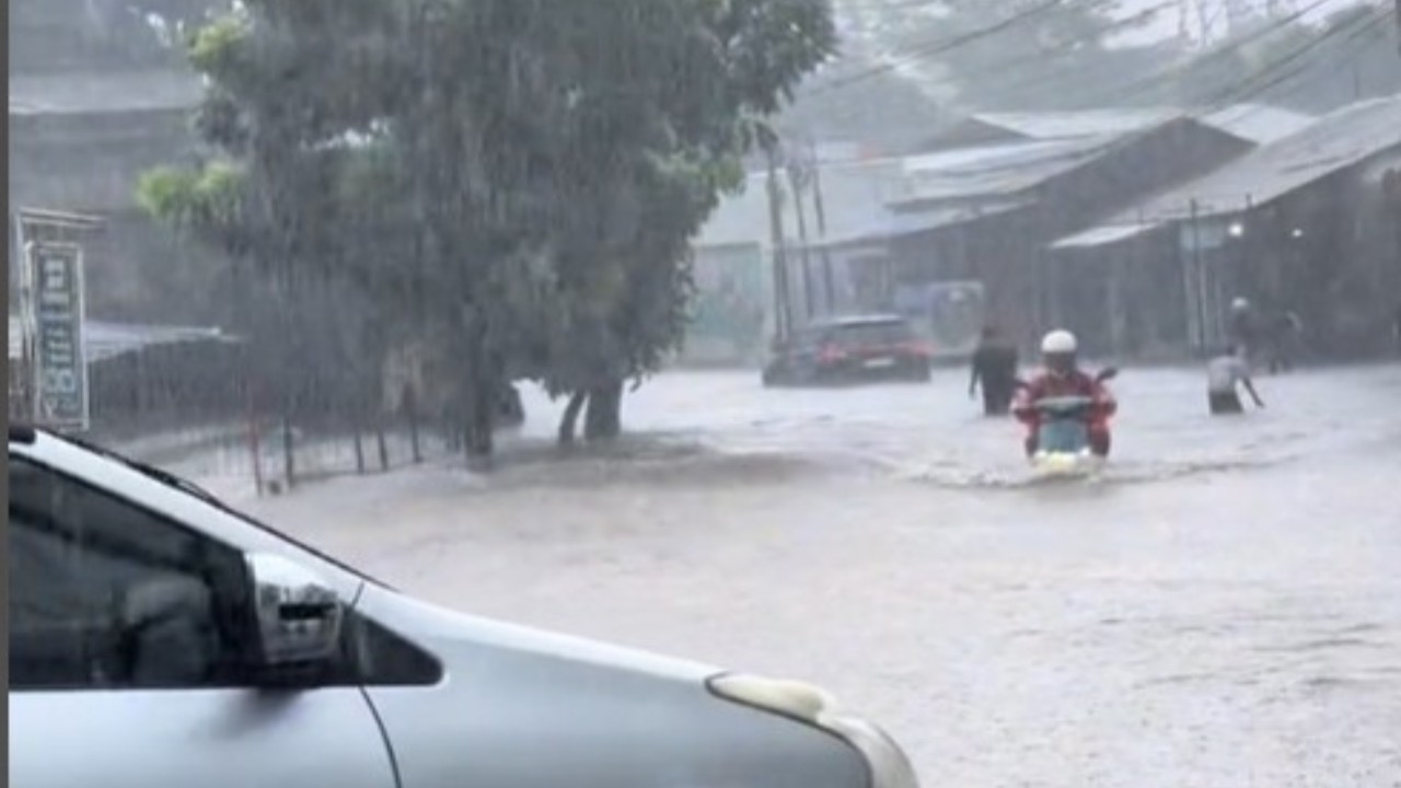 emak-emak yang dengan santainya menerjang banjir menggunakan sepeda listriknya. (Tangkap layar)