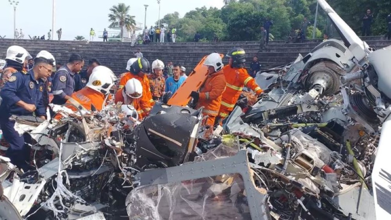 Tim penyelamat memeriksa puing-puing kecelakaan helikopter yang bertabrakan di udara, di Lumut, Perak. (Foto: handout/Departemen Pemadam Kebakaran dan Penyelamatan Perak)