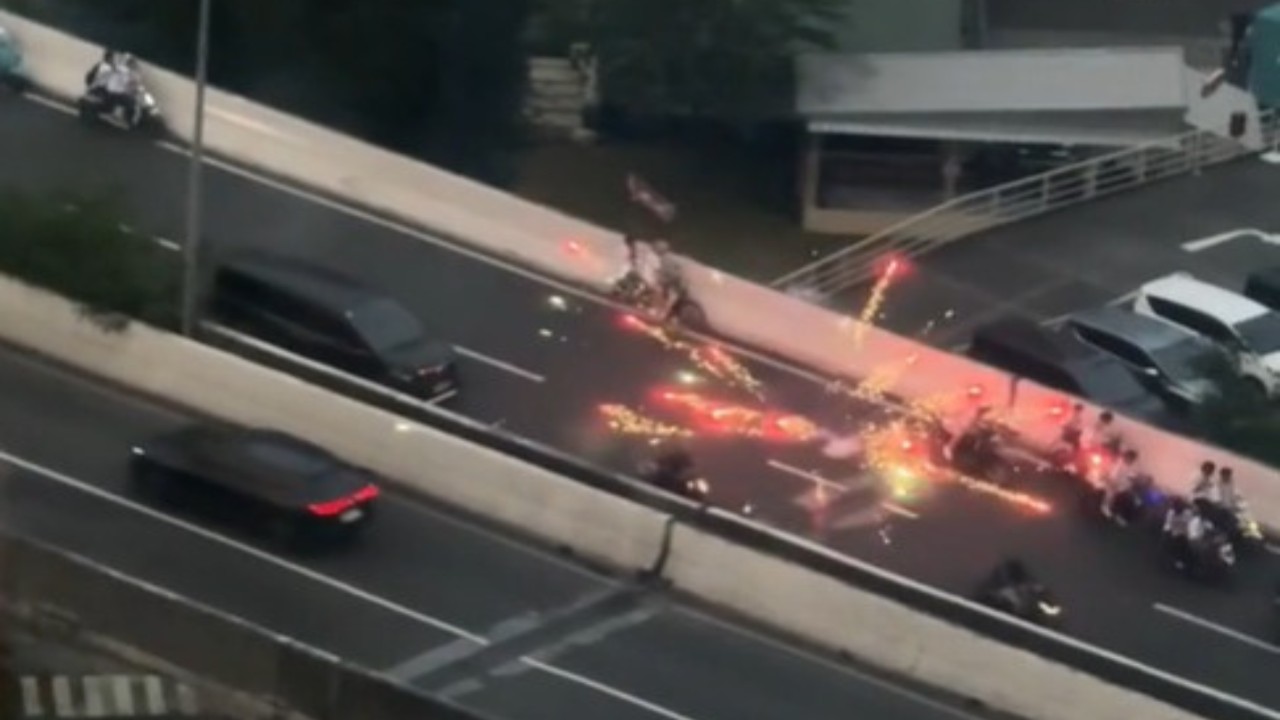 Sekelompok pemotor berkonvoi sambil membawa bendera dan menyalakan petasan . (Tangkap layar)