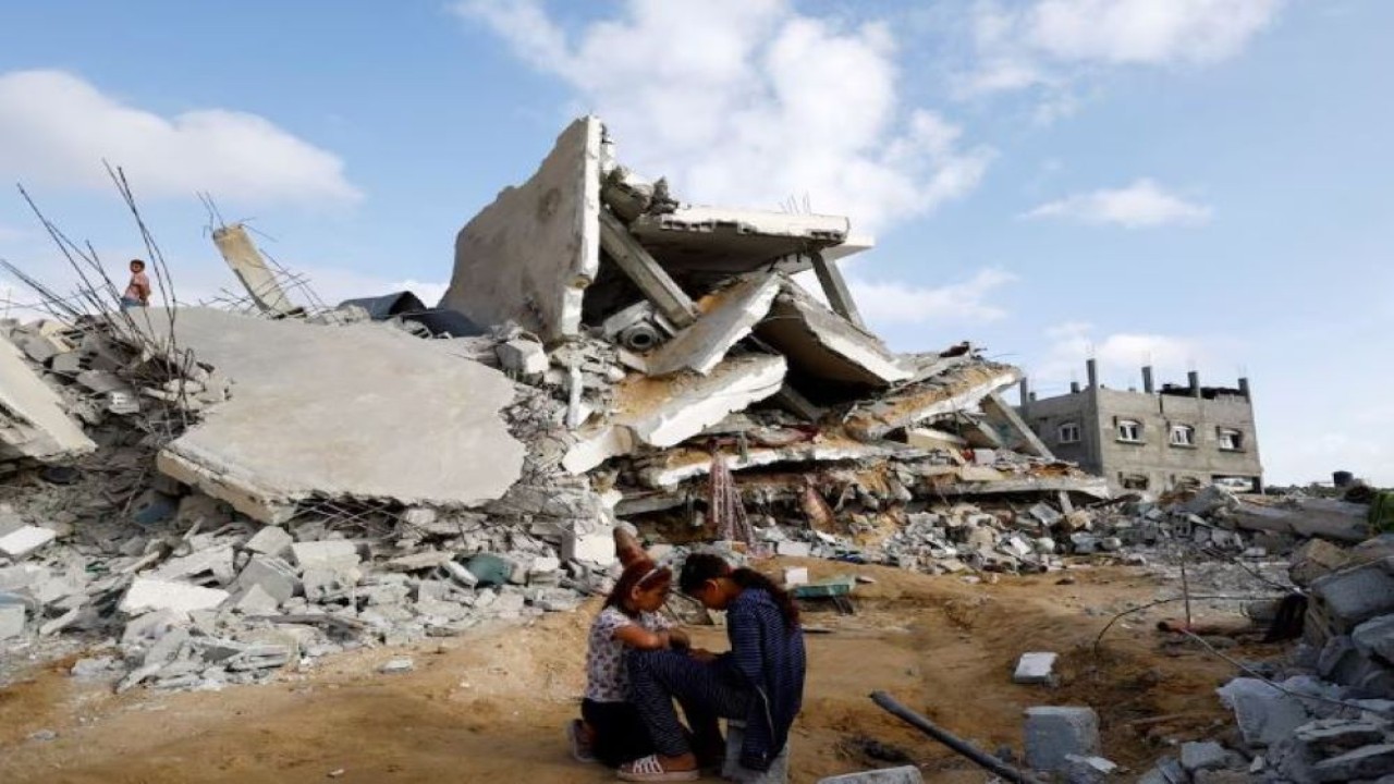 Anak-anak Palestina duduk di sebelah lokasi serangan Israel di sebuah rumah, di tengah konflik yang sedang berlangsung antara Israel dan kelompok militan Palestina Hamas, di Rafah, di selatan Jalur Gaza, pada 21 April 2024. (Foto: Dok/Mohammed Salem/Reuters)