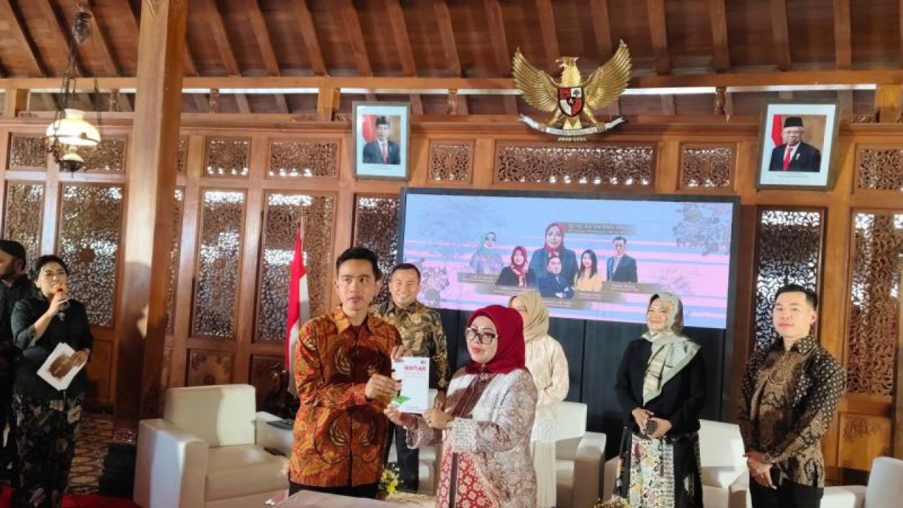 Putri Wakil Presiden (Wapres) Ma'ruf Amin, Siti Ma'rifah memberikan buku kepada Gibran Rakabuming Raka pada acara seminar Kiat Wanita Sukses: Ikhtiar Menjemput Rezeki, Memantaskan Usaha di Solo, Jawa Tengah, Senin (22/4/2024). ANTARA/Aris Wasita
