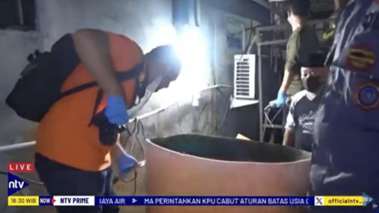 Petugas memeriksa mayat laki-laki yang ditemukan tewas di dalam toren air