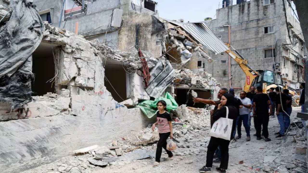 Warga Palestina memeriksa kerusakan sebuah bangunan, menyusul serangan Israel di kamp Nur Shams, Tulkarm, di Tepi Barat yang diduduki Israel, 21 April 2024. (Foto: Dok/Raneen Sawafta/Reuters)