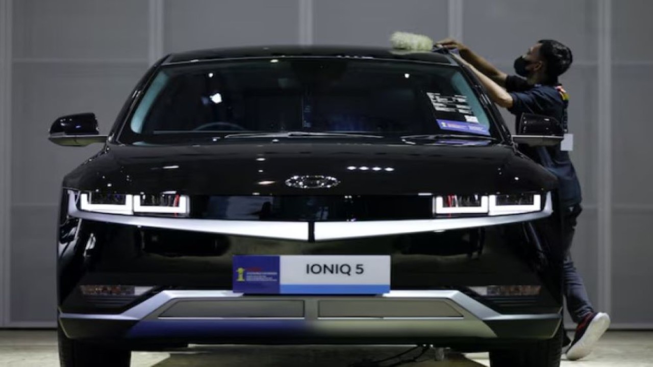Seorang pekerja membersihkan mobil listrik Hyundai Ioniq 5 saat Indonesia International Motor Show (IIMS) di Jakarta, 16 Februari 2023. (Foto: Willy Kurniawan/Reuters)