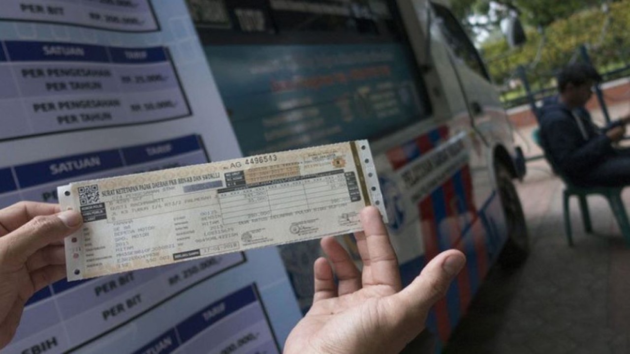 Warga menunjukkan STNK yang baru diperpanjang di Samsat keliling, Jakarta. (Foto: Antara)