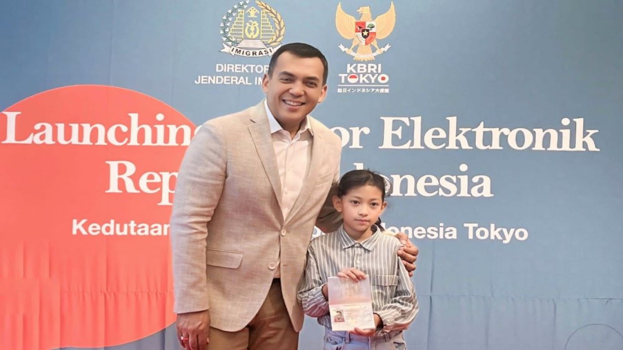 Direktur Jenderal Imigrasi Silmy Karim menyerahkan secara simbolis e-paspor yang diterbitkan pertama kali oleh KBRI Tokyo kepada warga negara Indonesia yang tinggal di Jepang ketika peluncuran layanan e-paspor di KBRI Tokyo, Jepang, Jumat (26/7/2024). (Foto: Istimewa)