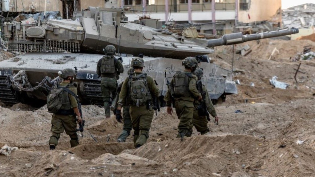 Tentara Israel berjalan di antara puing-puing, di tengah invasi darat yang sedang berlangsung terhadap kelompok Islam Palestina Hamas di Jalur Gaza utara, 8 November 2023. (Foto: REUTERS/Ronen Zvulun)