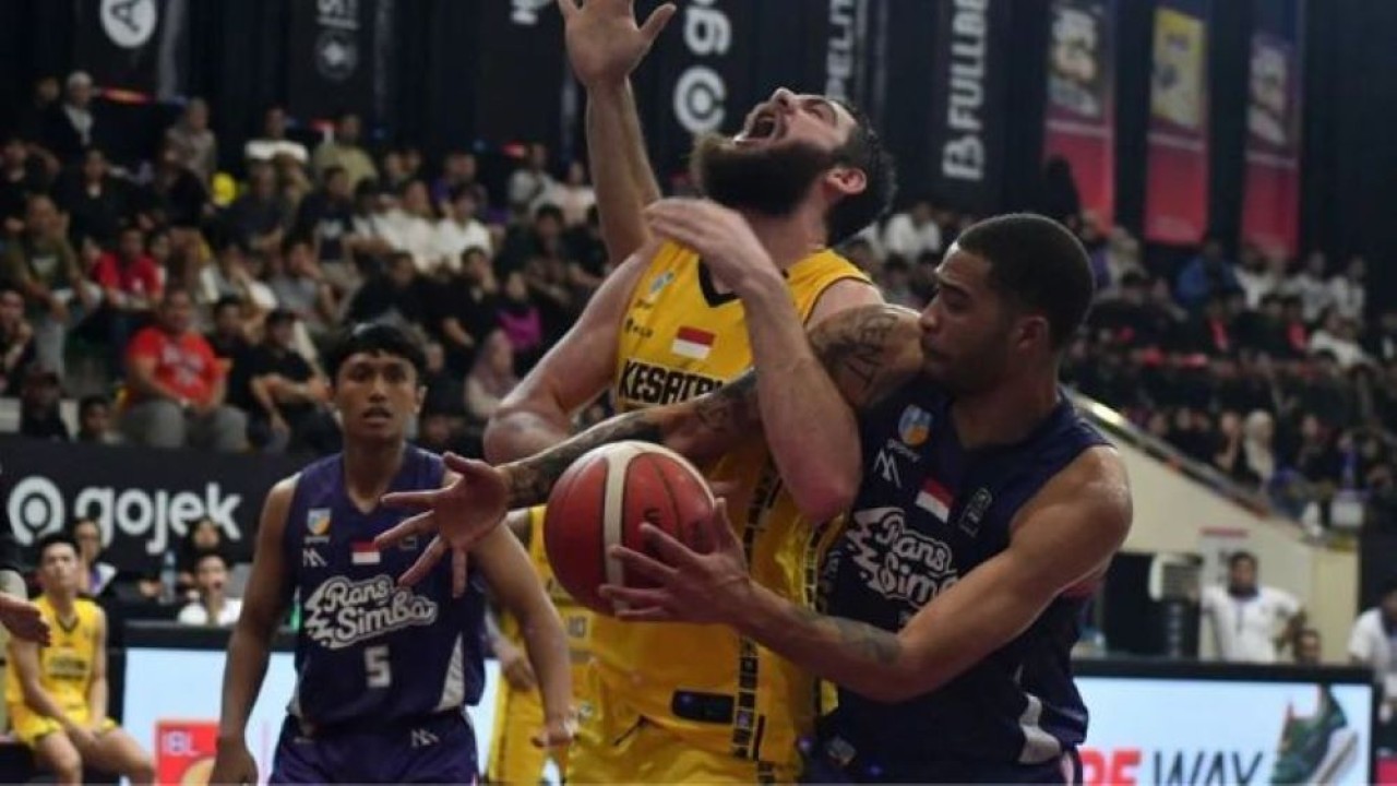Pebasket Kesatria Bengawan Solo William Joseph Artino (tengah) berebut bola dengan pebasket Rans Simba Bogor Kenyon Joseph Buffen (kanan) saat pertandingan IBL 2025 di Gymnasium Sekolah Vokasi IPB, Kota Bogor, Jawa Barat, Sabtu (11/1/2025). (Foto: Dok.Antara)