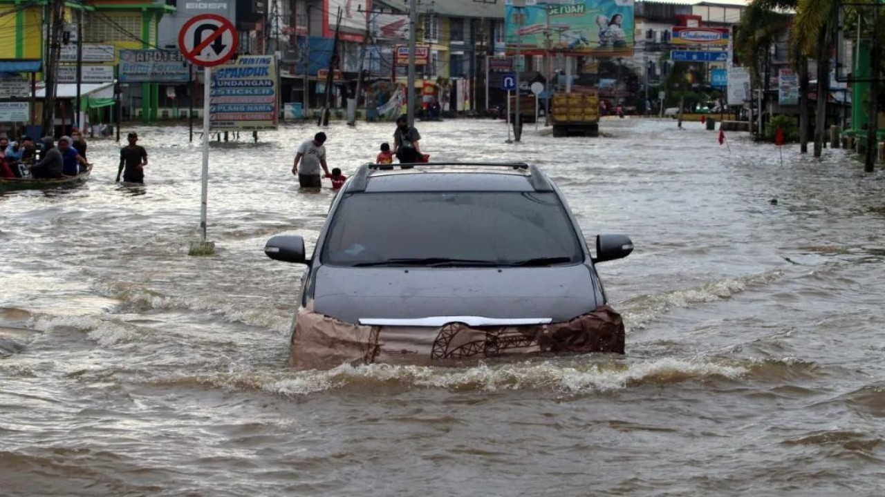 Ilustrasi. Sebuah mobil menerobos banjir. (Foto: ANTARA FOTO/Jessica Helena Wuysang/wsj)