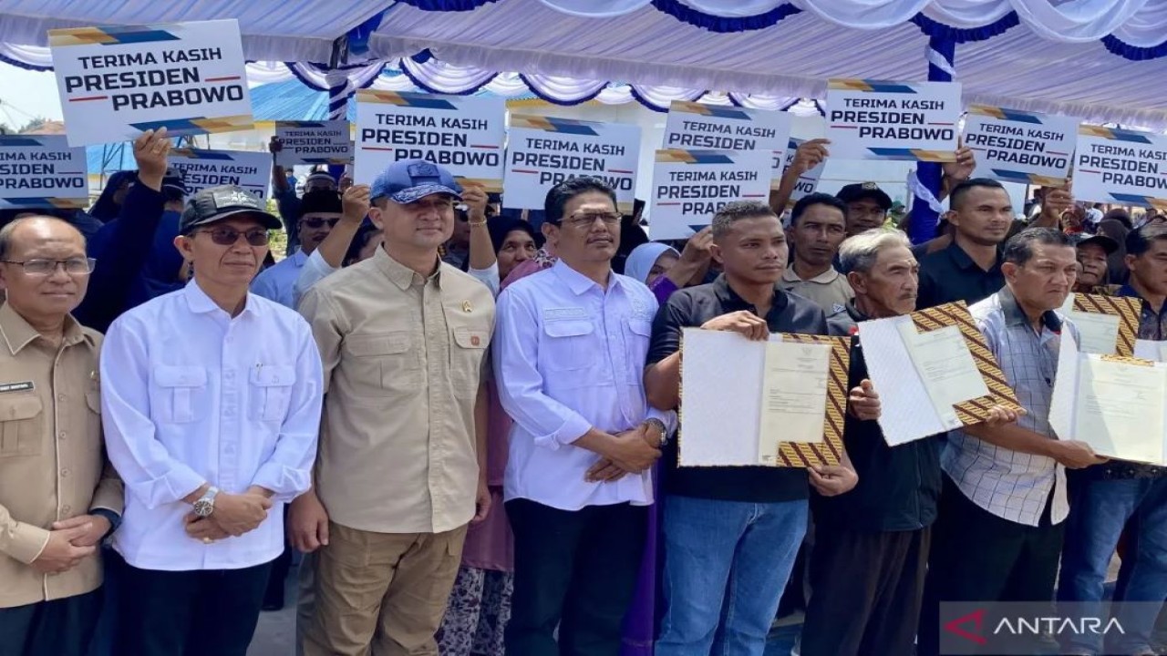 Penyerahan sertifikat hak milik (SHM) kepada warga yang terdampak proyek Rempang Eco City oleh Menteri Transmigrasi Iftitah Sulaiman Suryanegara (ketiga dari kiri) di Batam, Kepri, Selasa (12/8/2025). ANTARA/Amandine Nadja