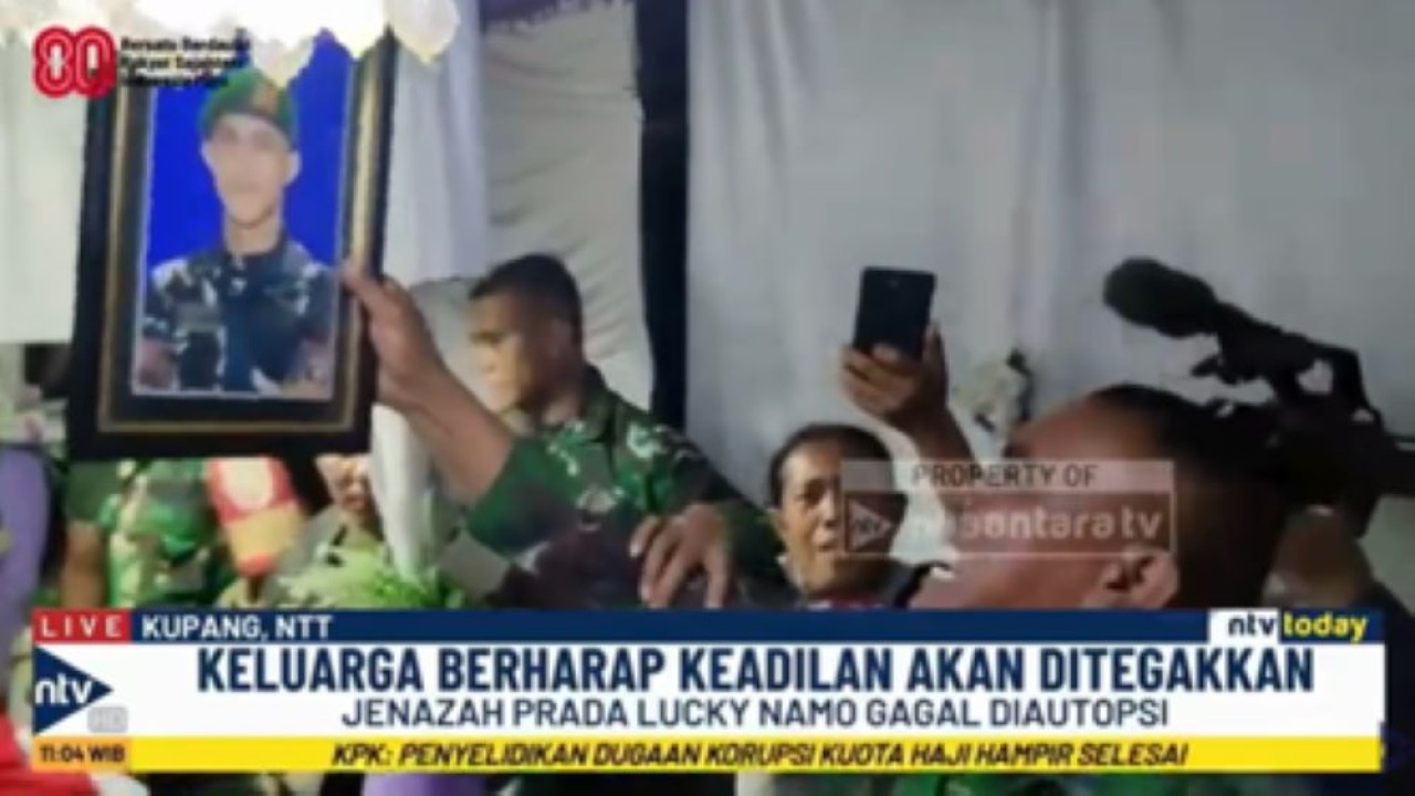 Serma Christian Namo ayah Prada Lucky Chepril Saputra Namo menangis sambil memegang foto anaknya