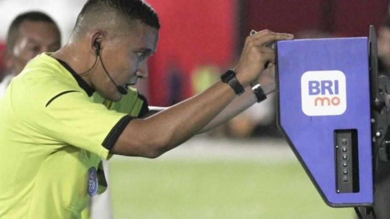 Wasit Agung Setiayawan (kanan) melihat Video Assistant Referee (VAR) setelah pesepak bola Malut United dijatuhkan penjaga gawang Borneo FC Nadeo Winata pada laga lanjutan BRI Liga 1 di Stadion Gelora Kie Raha Ternate, Maluku Utara, Senin (10/2/2025). Tuan rumah Malut United mengalahkan tamunya Borneo FC Samarinda dengan skor 3-0. (ANTARA)