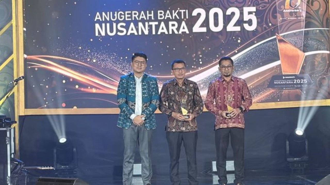 Pimpinan Redaksi Nusantara TV Abraham Silaban menyerahkan penghargaan Anugerah Bakti Nusantara 2025 kepada perwakilan Kabupaten Paser