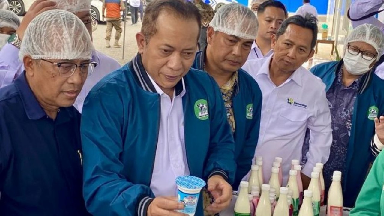 Menteri Koperasi Ferry Juliantono menunjukkan produk susu pasteurisasi saat meninjau pabrik KPBS Pangalengan di Kabupaten Bandung, Jawa Barat, Senin, 22 Desember 2025. (Foto: ANTARA/Rizka Khaerunnisa)