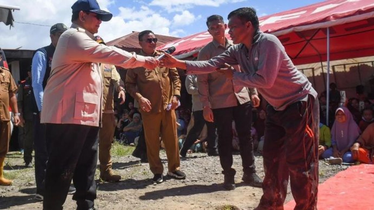 Presiden Prabowo Subianto (kiri) menyerahkan mikrofon kepada perwakilan pengungsi saat mengecek kondisi pengungsi terdampak banjir bandang di posko pengungsian di Desa Bambel Baru, Kabupaten Aceh Tenggara, Aceh, Senin (1/12/2025). Kunjungan Presiden tersebut untuk memantau kondisi pengungsi, memastikan distribusi bantuan tersalurkan dengan baik, serta memantau infrastruktur yang rusak akibat banjir bandang dan tanah longsor. ANTARA FOTO/Galih Pradipta/app. (Antara)