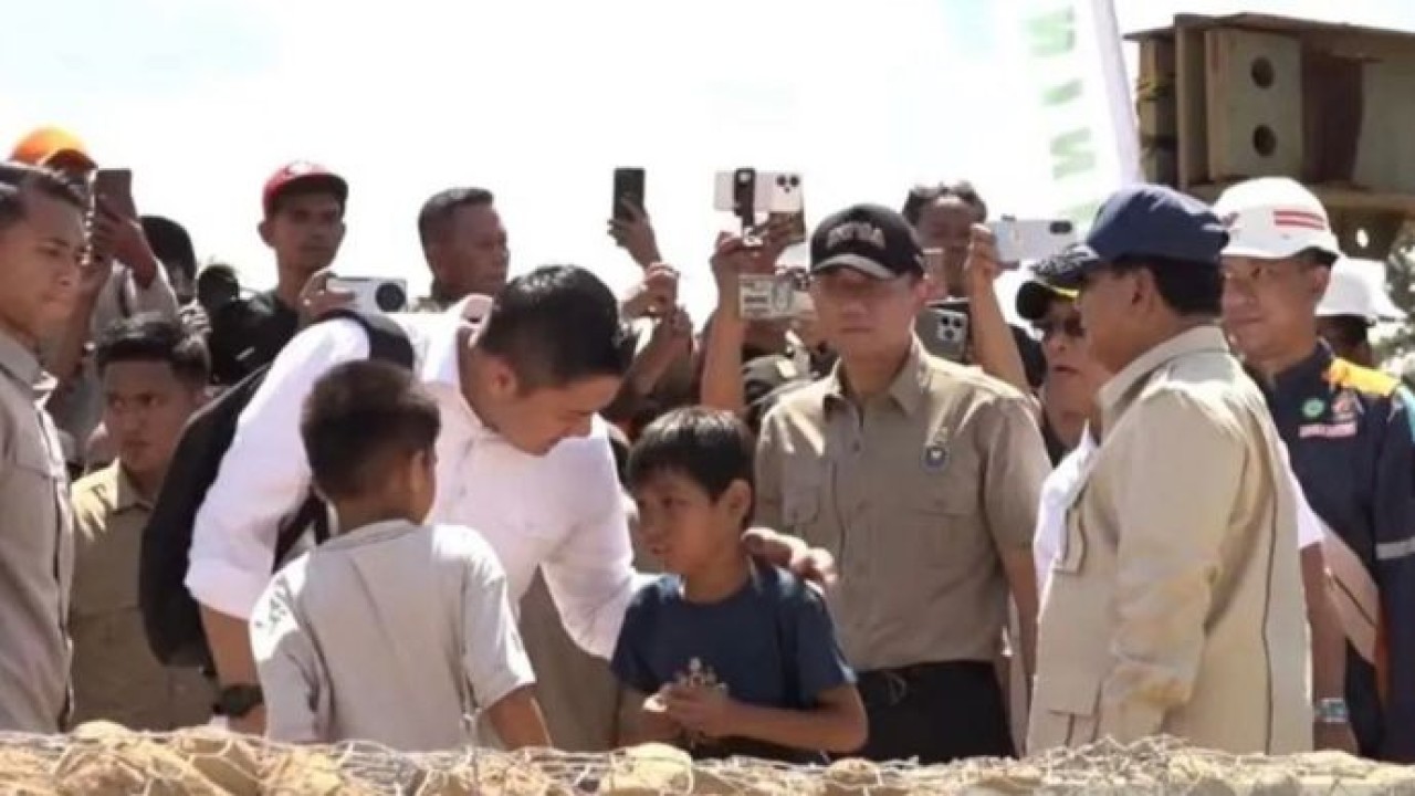 Sekretaris Kabinet Teddy Indra Wijaya tampak membagikan permen lolipop kepada anak-anak korban bencana saat mendampingi Presiden Prabowo Subianto meninjau jembatan Bailey atau jembatan sementara di Sungai Garoga, Kabupaten Tapanuli Selatan (Antara)