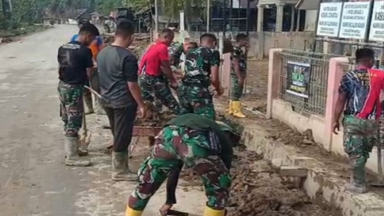 Puluhan anggota TNI bahu-membahu membersihkan sisa lumpur agar tidak membahayakan pengguna jalan sekaligus memperlancar mobilitas warga di Aceh Tamiang. (Foto: Istimewa)