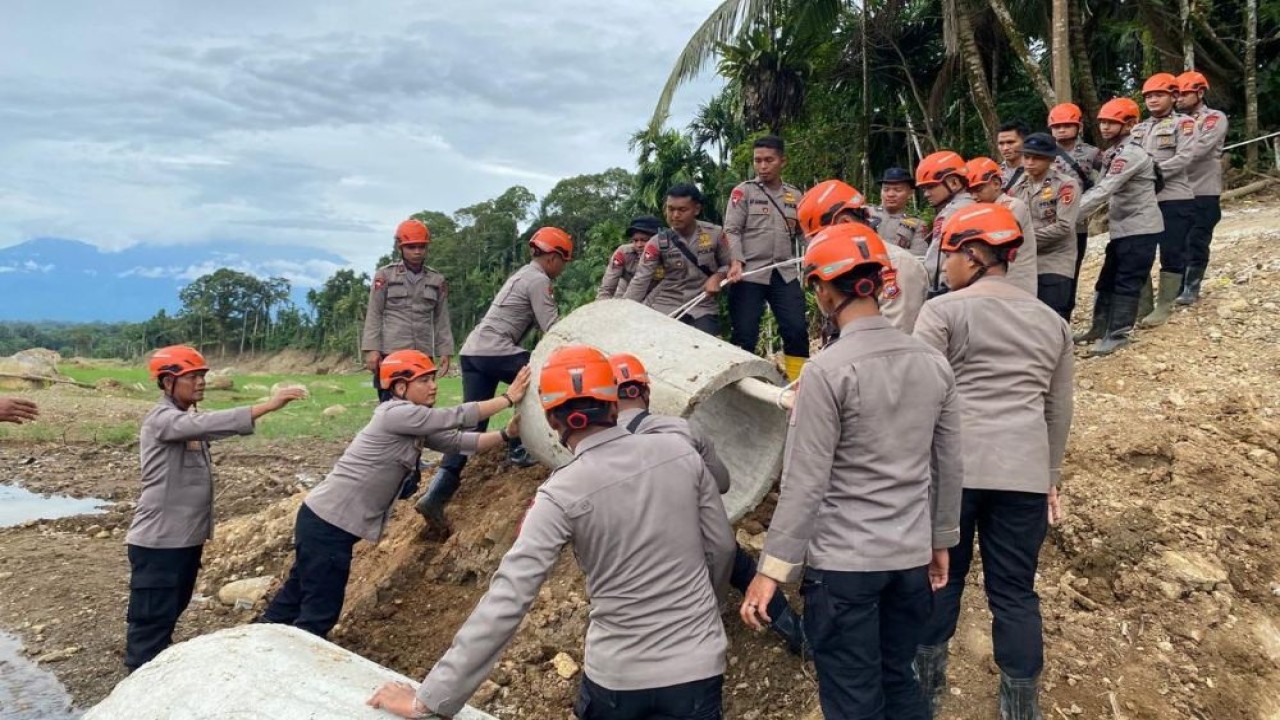 Anggota Satuan Brimob Polda Sumatra Barat bergotong royong memperbaiki gorong-gorong dan akses jalan yang terputus akibat banjir di Jorong Koto Tangah, Nagari Koto Alam Seberang Aia, Kecamatan Palembayan, Kabupaten Agam. (Foto: Istimewa)