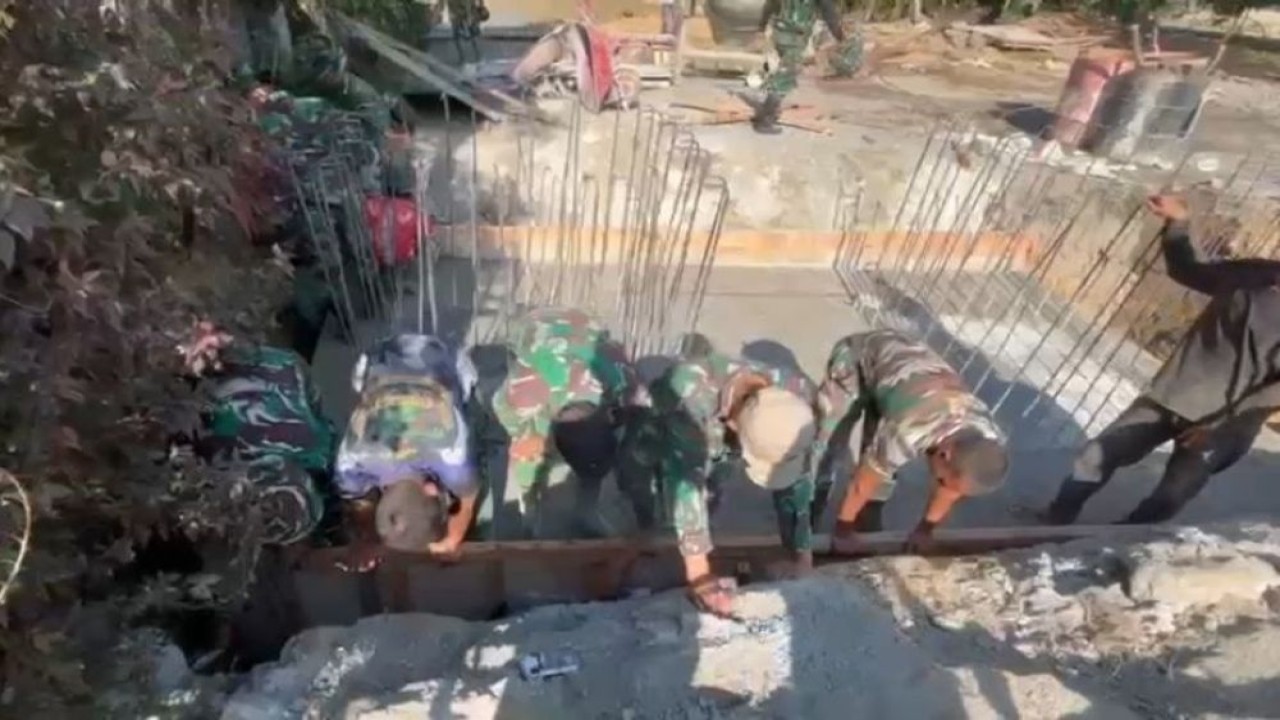 TNI dan warga bergotong royong mengangkut material dan mengecor fondasi jembatan, di Desa Burni Bius, Kecamatan Silih Nara, Aceh, pada Sabtu, 31 Januari 2026. (Foto: Dok/Istimewa)
