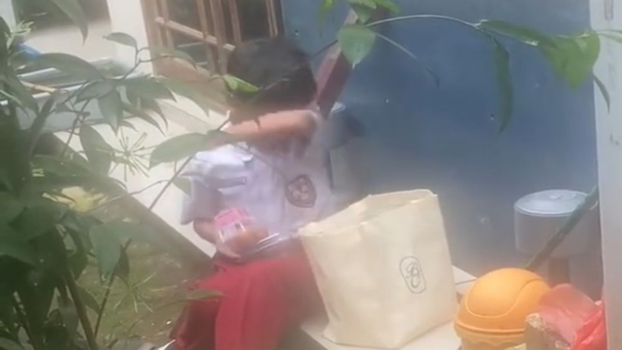 Seorang anak sekolah dasar tampak berjalan pulang sambil menenteng sebuah kantong berisi paket Makan Bergizi Gratis (MBG) yang didapatkan dari sekolahnya. (Foto: Dok/Istimewa/Bakom RI)