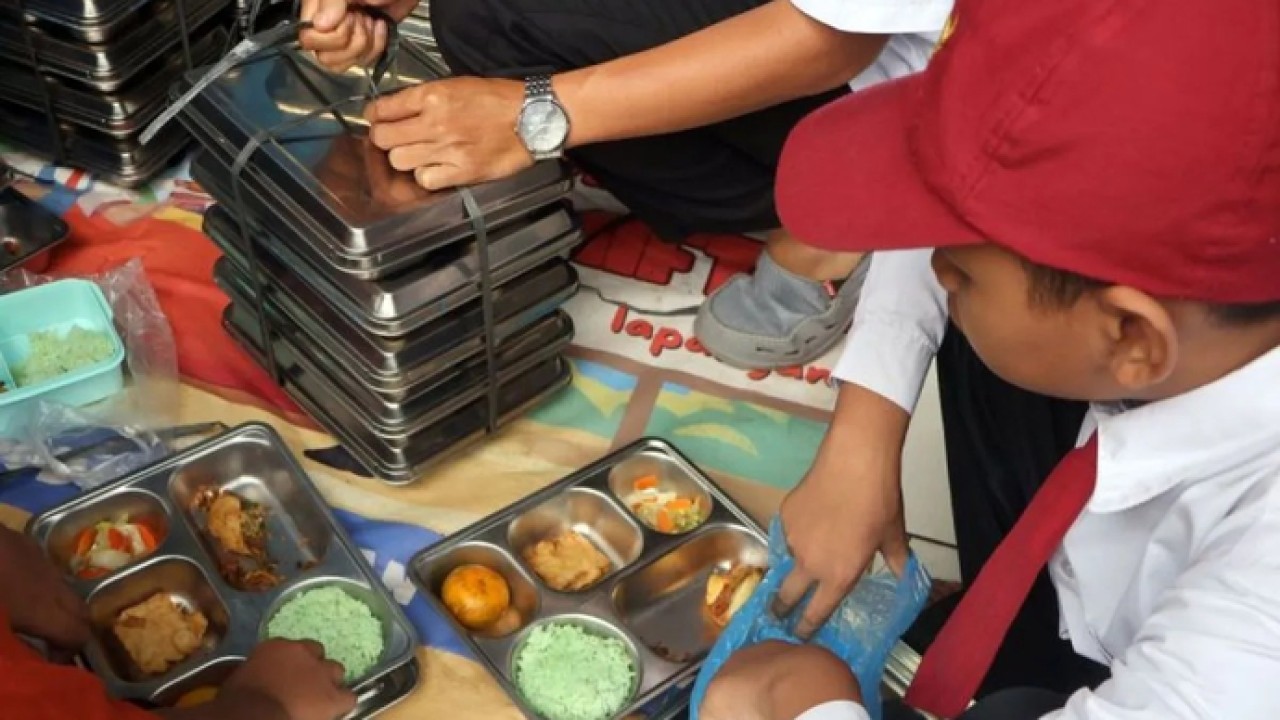 Guru membagikan Makanan Bergizi Gratis (MBG) pada siswa saat sekolah diliburkan akibat bangunan ambruk di Madrasah Ibtidaiyah Miftahul Falah, Gunungputri, Kabupaten Bogor, Jawa Barat, Senin (2/2/2026). ANTARA FOTO/Yulius Satria Wijaya/rwa. (Antara)