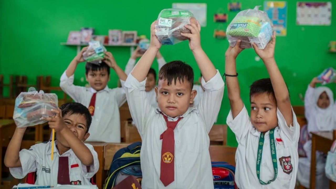 Sejumlah siswa menunjukkan menu Makan Bergizi Gratis (MBG) di SD Negeri 1 Bojongleles, Lebak, Banten, Senin (23/2/2026). Pemerintah tetap mendistribusikan paket MBG selama bulan suci Ramadhan yang dikhususkan bagi siswa untuk dibawa pulang sebagai menu berbuka puasa guna memastikan pemenuhan gizi anak serta mendukung program percepatan penurunan angka stunting. ANTARA FOTO/Muhammad Bagus Khoirunas/YU (Antara)