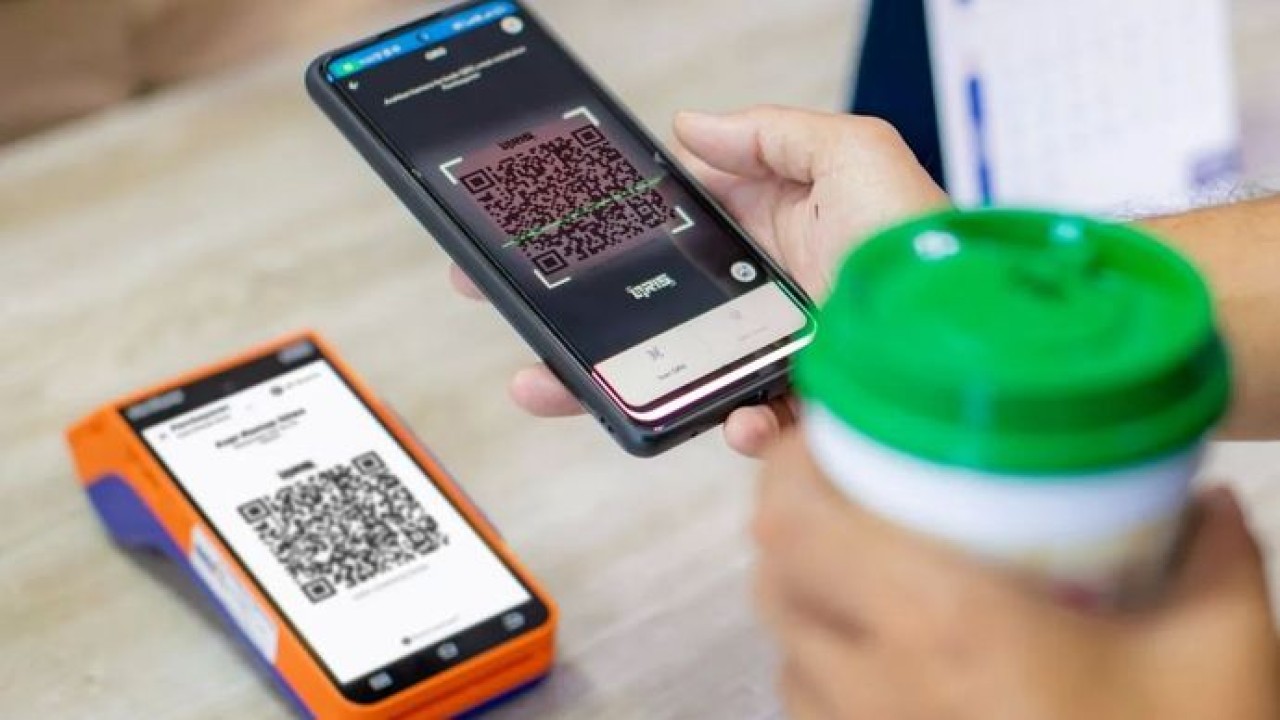 Ilustrasi - nasabah memindai QR code menggunakan aplikasi QRIS (Antara)