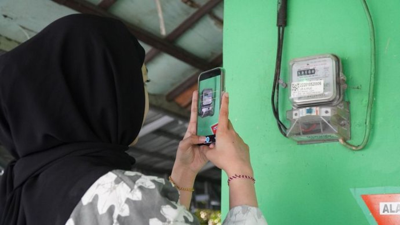 Ilustrasi pelanggan tengah memanfaatkan fitur SwaCAM di aplikasi PLN Mobile untuk mencatat stand meter listrik