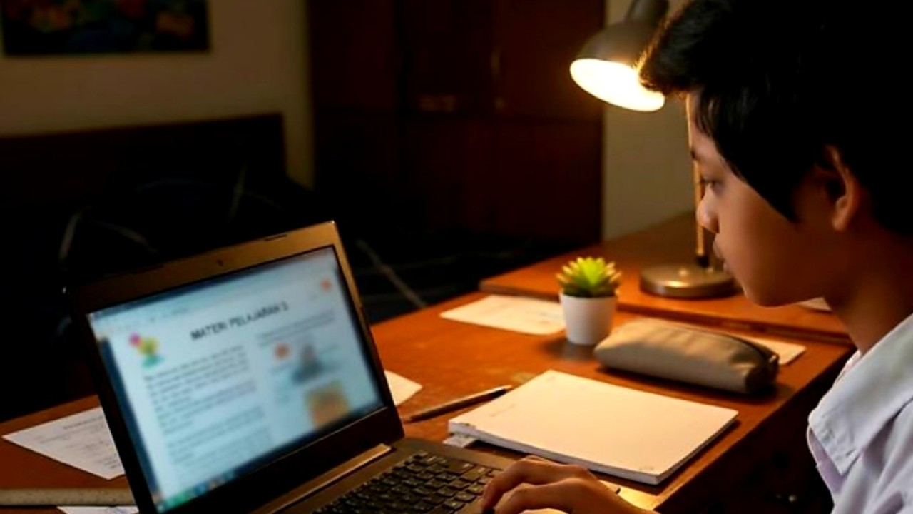 Ilustrasi seorang anak sedang fokus mengerjakan tugas menggunakan laptop di kamarnya pada malam hari.