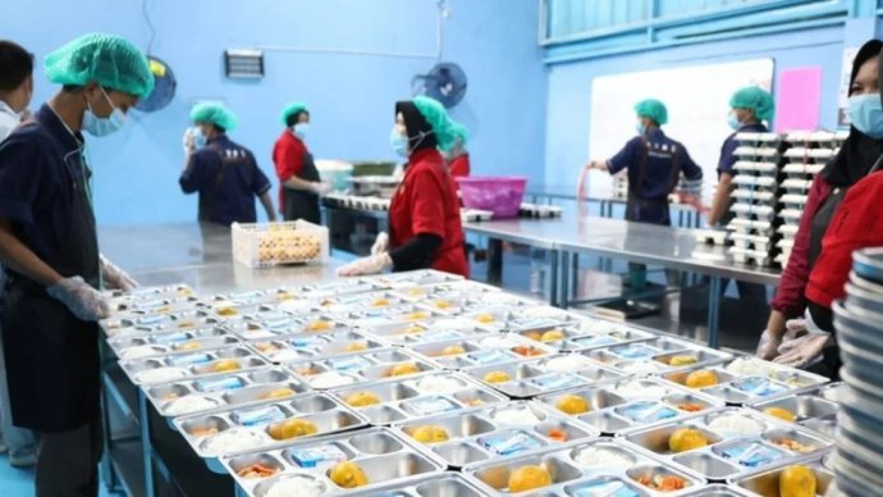Ilustrasi - Petugas satuan pelayanan pemenuhan gizi (SPPG) menyajikan menu makanan yang akan didistribusikan ke sekolah dalam program MBG. (Antara)