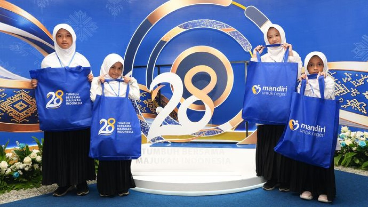 Anak-anak penerima manfaat tersenyum ceria menunjukkan tas bantuan dalam rangkaian program TJSL Mandiri untuk Negeri, menyambut perayaan HUT ke-28 Bank Mandiri yang mengusung tema “Tumbuh Bersama Majukan Indonesia”.
