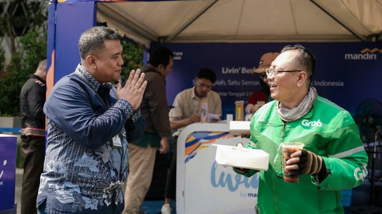 Perwakilan manajemen Bank Mandiri menyapa dan menyerahkan paket makanan dan minuman kepada pekerja rentan dalam program Livin’ Mandiri Berbagi yang digelar serentak di 12 titik wilayah Indonesia sebagai bagian dari rangkaian HUT ke-28 Bank Mandiri.