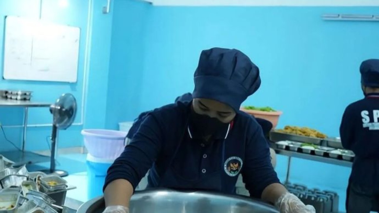 Seorang petugas SPPG tengah mendinginkan makanan usai dimasak untuk menjaga keamanan pangan Program MBG (Antara)