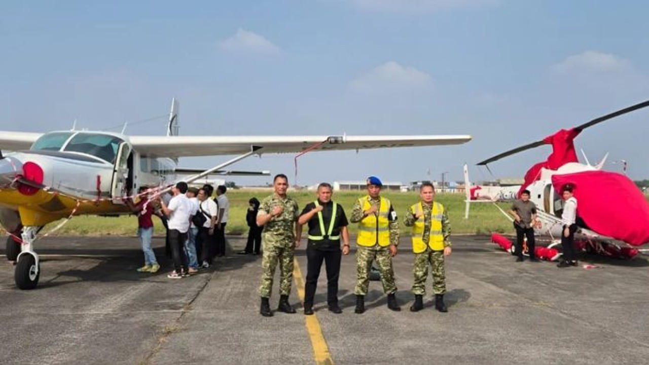 Pihak Jampidmil Kejaksaan Agung berfoto di depan satu unit pesawat Textron Aviation Inc dan satu unit helikopter Bell 505 yang disita terkait kasus dugaan korupsi pengadaan motor listrik oleh PT YAT pada tata kelola program Makan Bergizi Gratis (MBG) di Badan Gizi Nasional (BGN) tahun 2025-2026. (Antara)